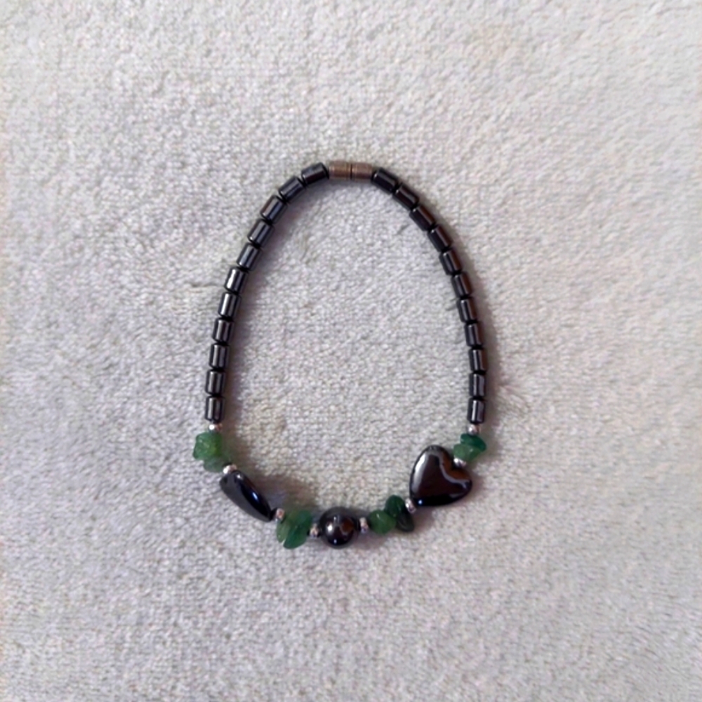 Black metallic heart bracelet with dark green gems.